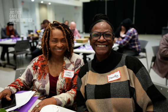 Two Black women smiling at a Los Angeles County Justice Care & Opportunities Department event.