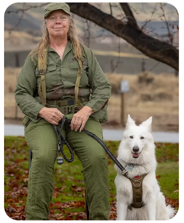Woman in military uniform with white German Shepherd dog