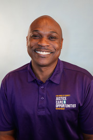 Man in purple Los Angeles County Justice Care Opportunities shirt smiles